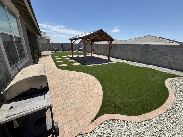 Curved artificial turf lawn with paver patio and wood pergola