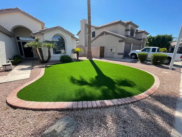 Front yard artificial turf lawn with a brick border and landscape rock