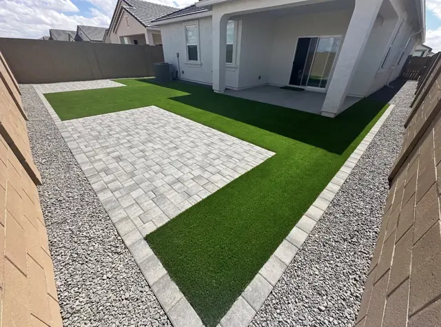 Light gray paver patio next to an artificial turf lawn