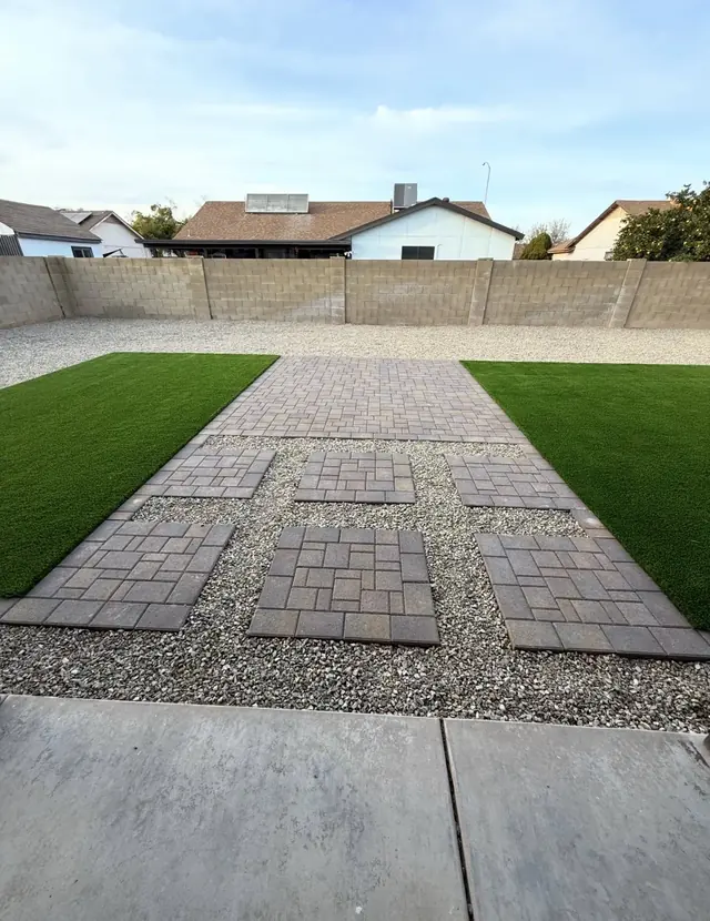 Paver stepping squares in landscape rock between two artificial turf lawns